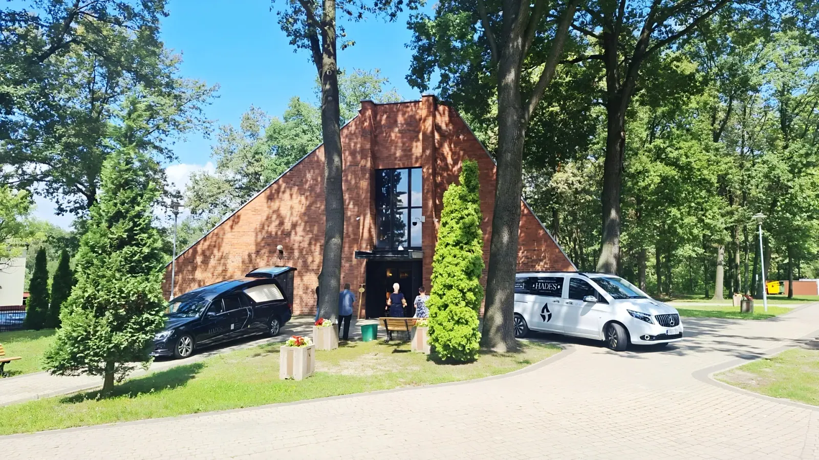 Dwa pojazdy Hadesa przed kaplicą cmentarną